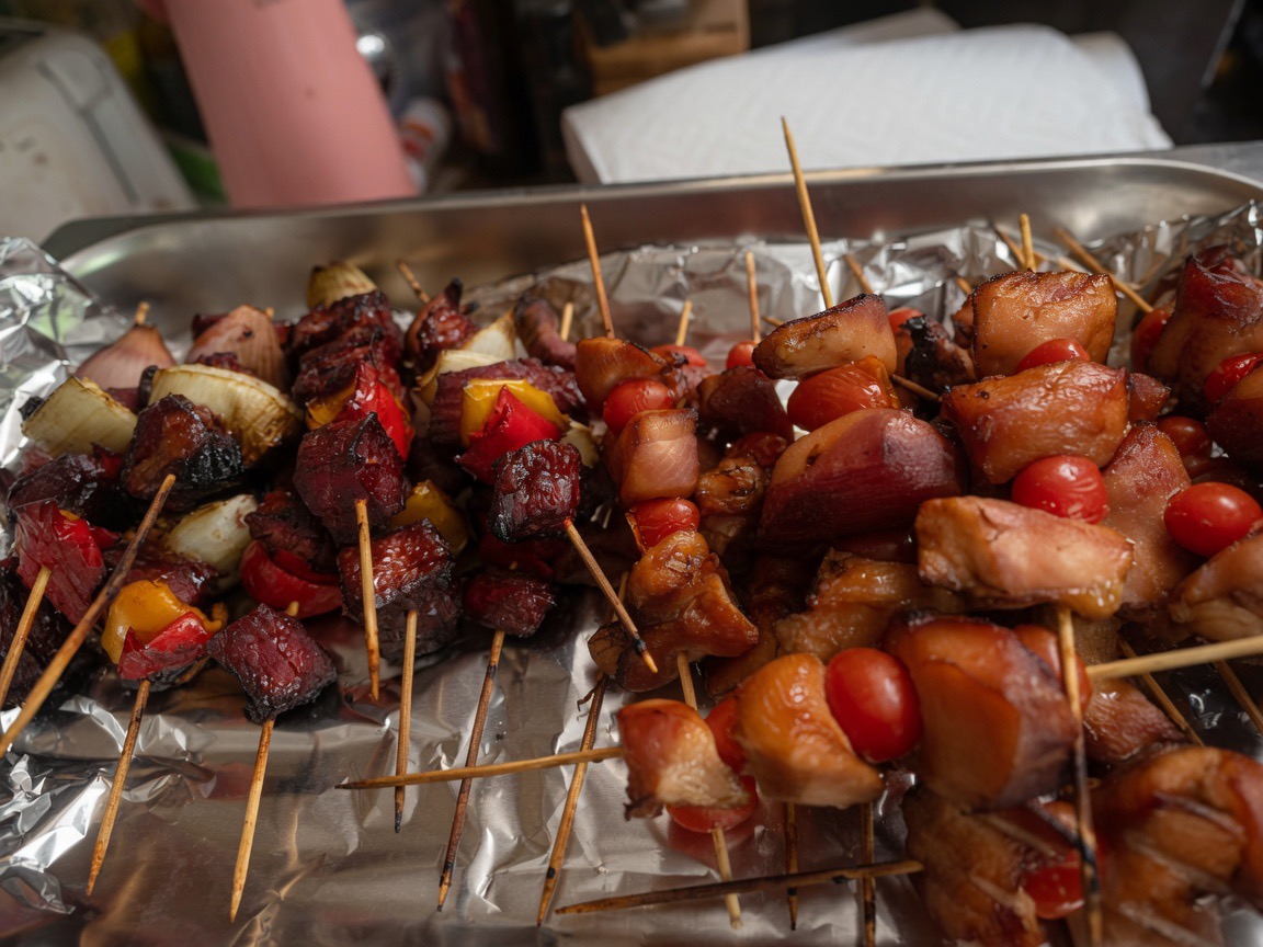Grilled beef and chicken skewers with peppers and onion